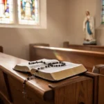 Holy Mary, Mother of God: Meaning and Prayer Rosary and Bible beside a distant statue of Mary in soft church light