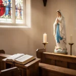 Statue of Mary beside candles in a quiet church
