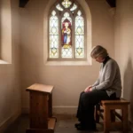 Person praying quietly in a sunlit church chapel