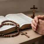 Rosary and crucifix beside an open Bible for sorrowful mystery prayer